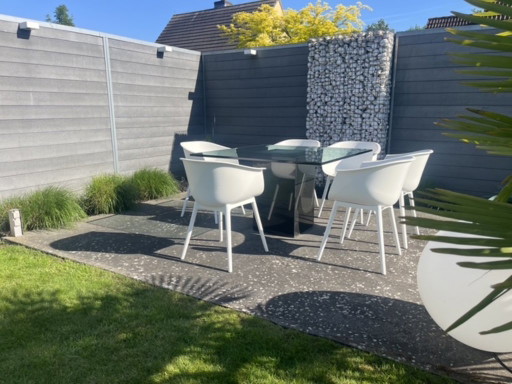Mesa de jardín cuadrada de cristal de diseño con base de columna de granito negro.