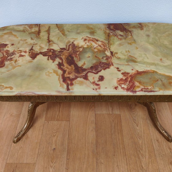 Image 1 of Table basse ovale de style Hollywood Regency avec plateau en marbre et piètement en laiton.