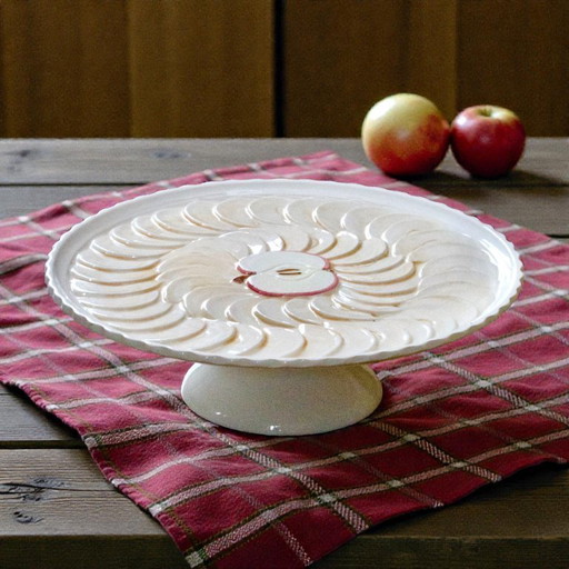 Large earthenware pie dish on a pedestal, apple pie