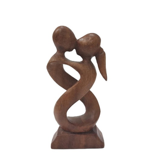 Escultura de madera que representa a una pareja enamorada abrazándose.