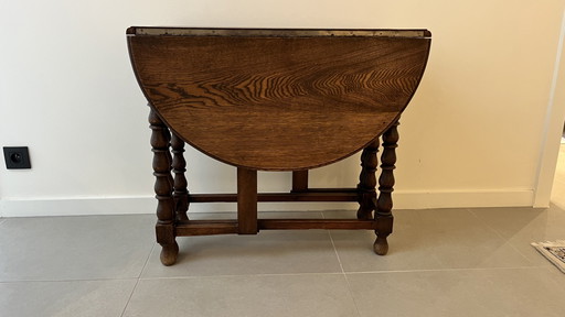 Mesa plegable de roble macizo estilo neojacobino inglés con patas abatibles.
Circa 1925–1940