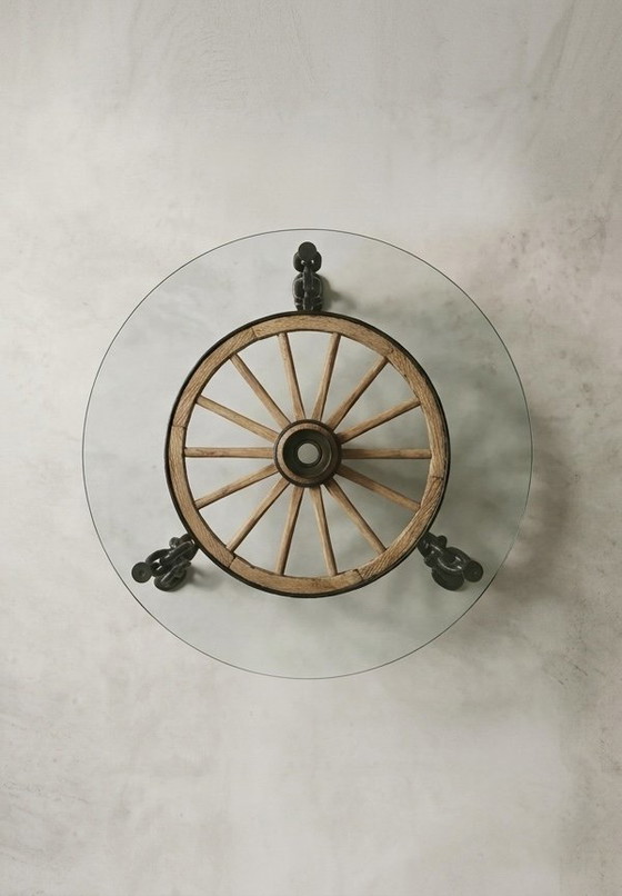 Image 1 of Tafel in de vorm van een wagenwiel met een massief glazen blad.