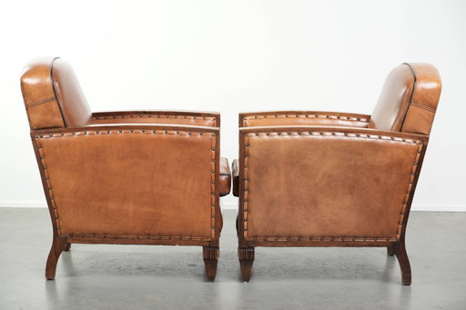 2 x Prachtige schapenleren Art Deco fauteuil met mooi houtsnijwerk en zwarte biezen