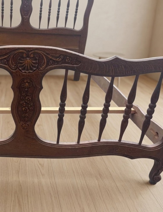 Image 1 of Vintage houten bedframe met houtsnijwerk, sierlijk hoofd- en voetbord, eerste helft 20e eeuw