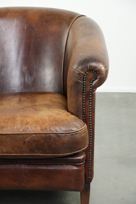 Image 1 of Stoere en begeerlijke vintage schapenleren clubfauteuil met een mooi patina en warme kleuren