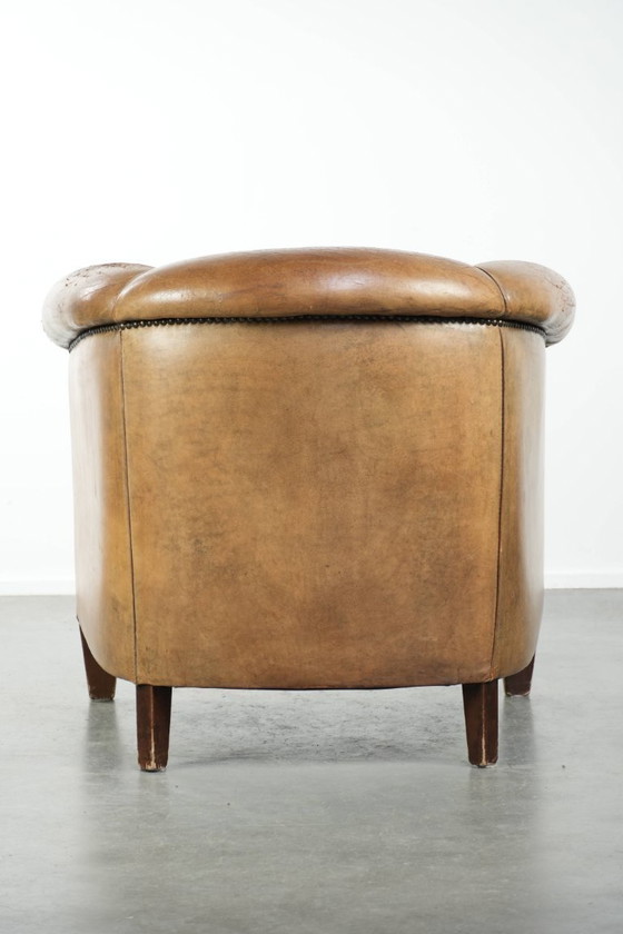 Image 1 of Vintage sheepskin club armchair with beautiful colors and finished with decorative nails.