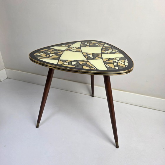 Image 1 of Tavolino da caffè vintage. Triangolare, a tre gambe, a forma di "rene". Piano in vetro con motivo retrò. Anni '50/'60.