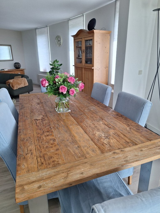 Robust dining table with teak top and stainless steel legs
