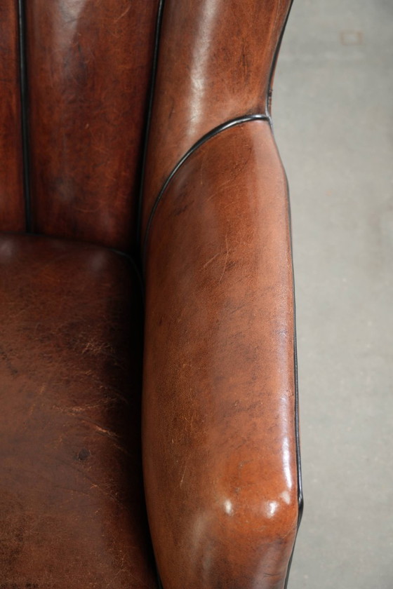 Fauteuil unique en peau de mouton aux couleurs chaudes et profondes, orné d'un passepoil noir. – Leather (photo 8 of 14)