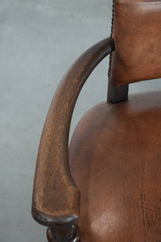 Image 1 of Elegante antieke schapenleren bureaustoel met een zwaar houten frame