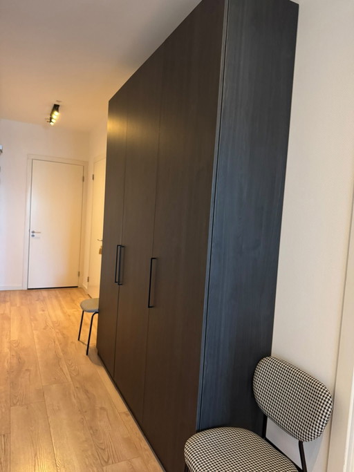Custom-made wardrobe / clothes cupboard in brown/black wood. 260 high