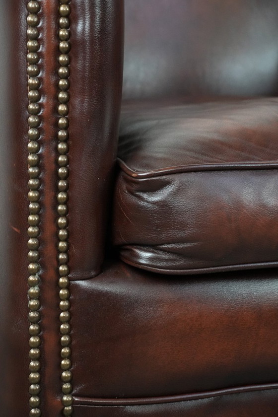 Image 1 of Sillón club de piel de vaca en buen estado, de un lujoso color rojo/marrón.