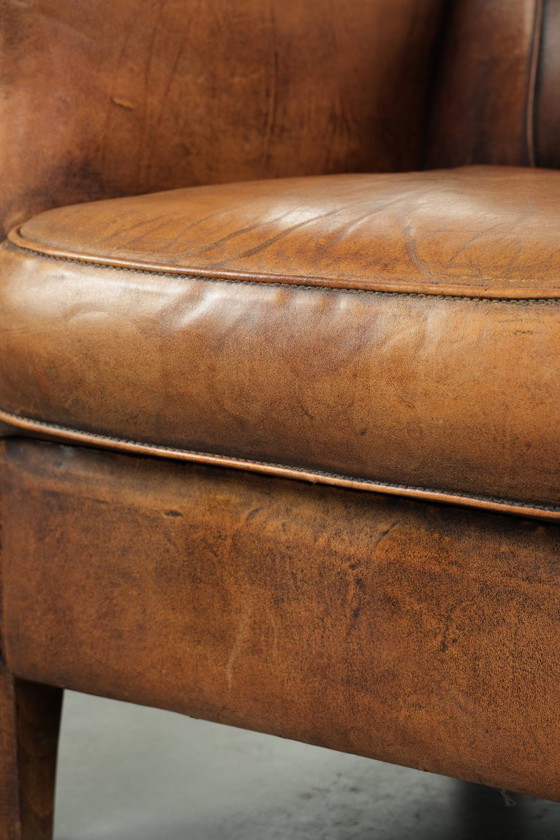Comoda poltrona in pelle di pecora, dal carattere deciso, rifinita con borchie decorative e una splendida (photo 13 of 13)