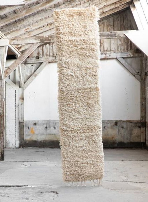 Dos alfombras marroquíes hechas a mano: una blanca y otra de cobre, además de una alfombra de pasillo.