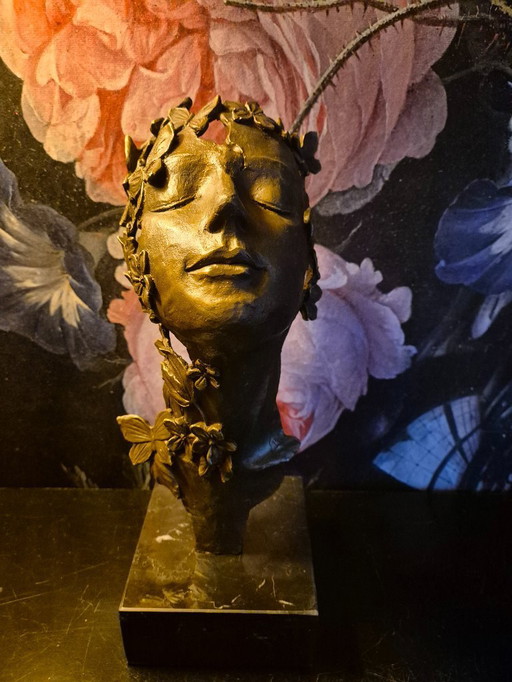 Statue en bronze de visage de femme avec des papillons et des fleurs