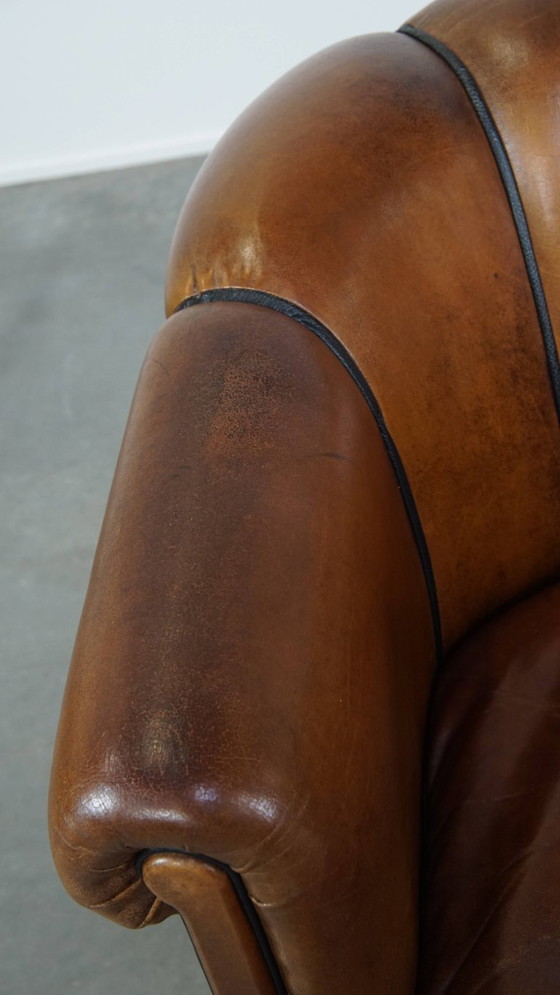 Image 1 of Unieke vintage cognac kleurige lederen clubfauteuil met een afwerking met zwarte biezen