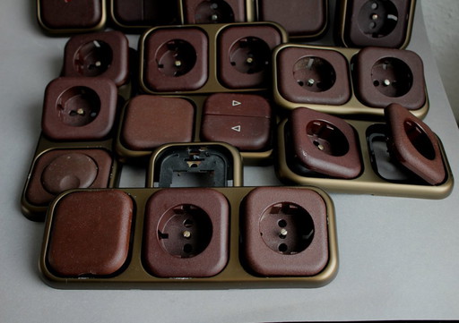 Large collection of vintage brown sockets and light switches with antique gold frames, 1960s/70s