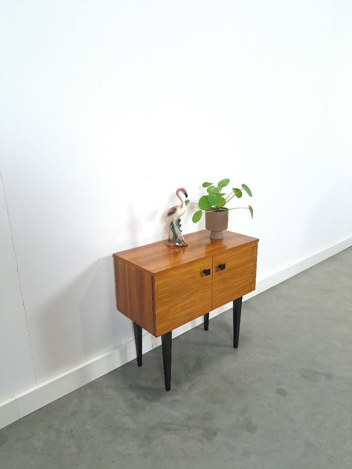 Small cabinet with black high legs and 2 doors