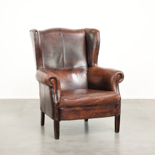 Spacious vintage sheepskin wing armchair in a deep brown color, finished with decorative nails. – fauteuils, Leather