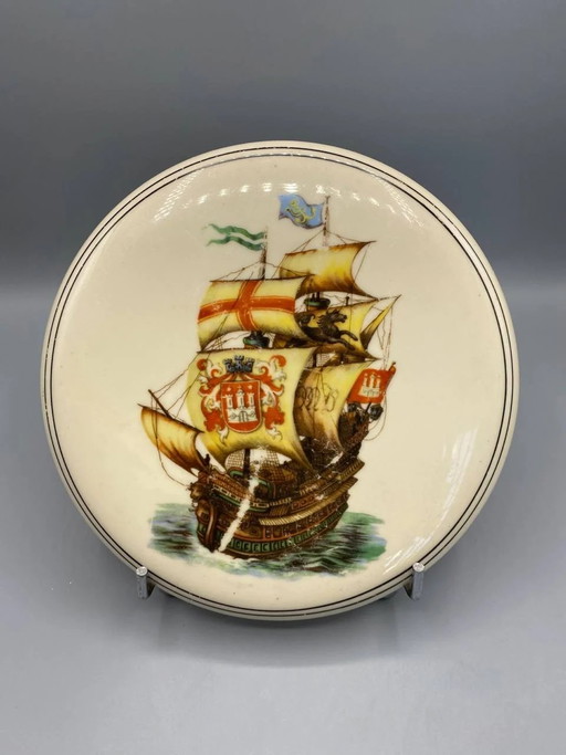 Sottopentola in maiolica color crema, a forma di galeone con stemma di Amburgo, decorazione marittima policroma, 20 cm.