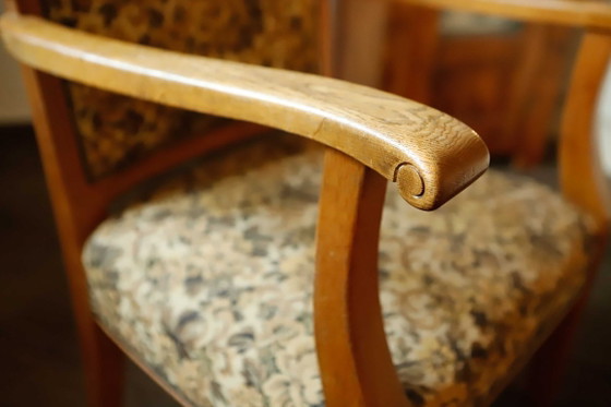 Image 1 of Vintage salonfauteuil met bloemenpatroon op de bekleding en sierlijke armleuningen.
