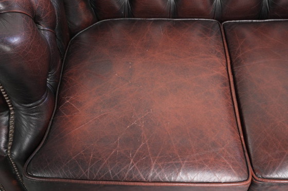 Image 1 of Canapé Chesterfield 2 places en cuir de vachette anglais ancien rouge/marron, au style magnifique et au charme intemporel.