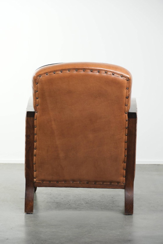 Image 1 of Unieke schapenleren art Deco fauteuil met mooi houtsnijwerk en zwarte biezen