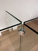 Esstisch aus Glas im Stil „Leon Rosen“ mit facettierter Kante.