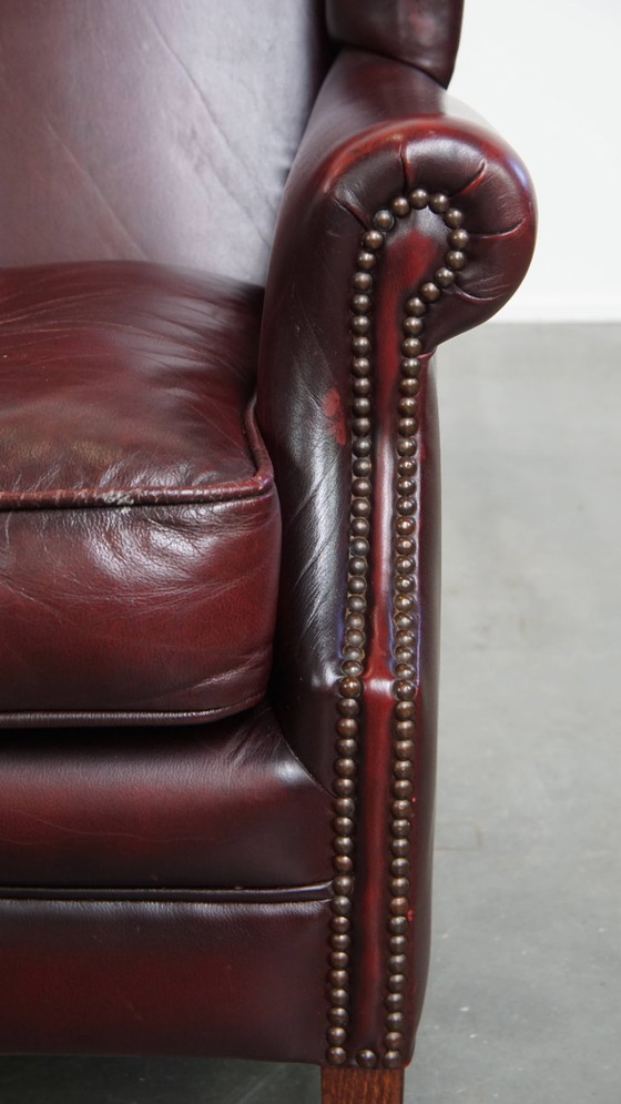 Image 1 of Bordeauxrode Rundleren Oorfauteuil in Engelse Stijl