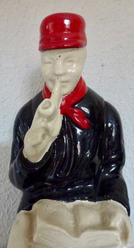 Image 1 of A set of decorative bookends depicting an elderly couple sitting on chairs.