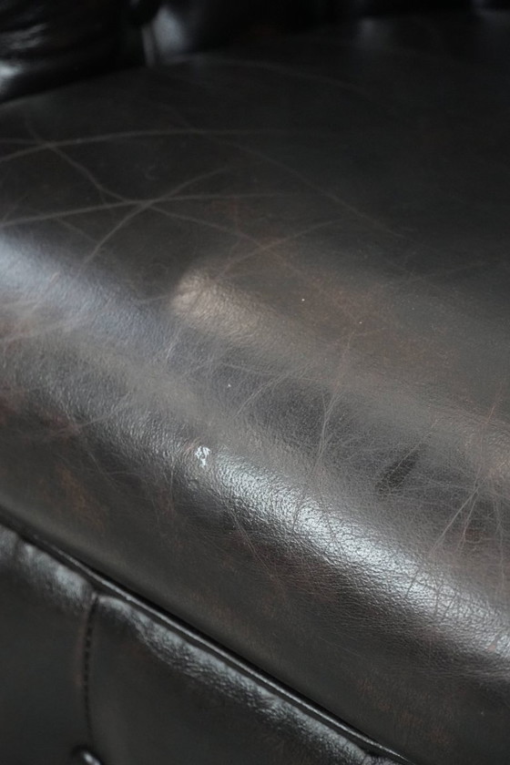 Image 1 of Donkere luxe rundleren Chesterfield clubfauteuil in Engelse stijl, afgewerkt met siernagels