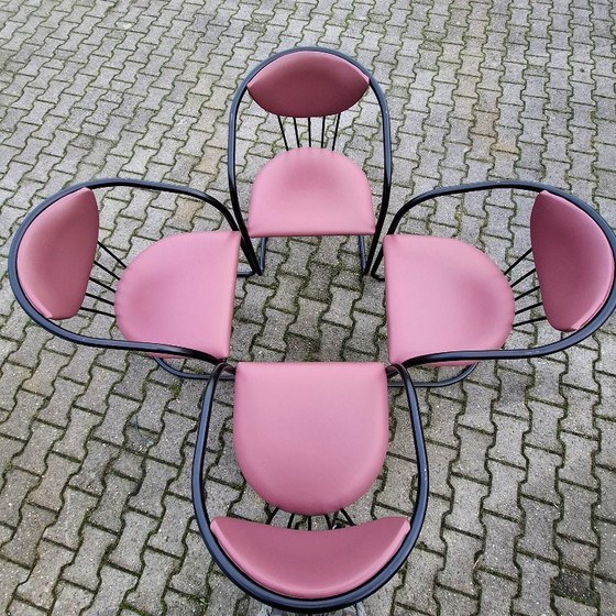 Image 1 of This is a set of four vintage 'Memphis' style chairs with a black metal frame and burgundy upholstery.