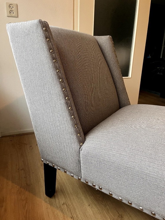 Image 1 of Le fauteuil Columbia d'Eichholtz, un fauteuil lounge design orné de clous décoratifs.