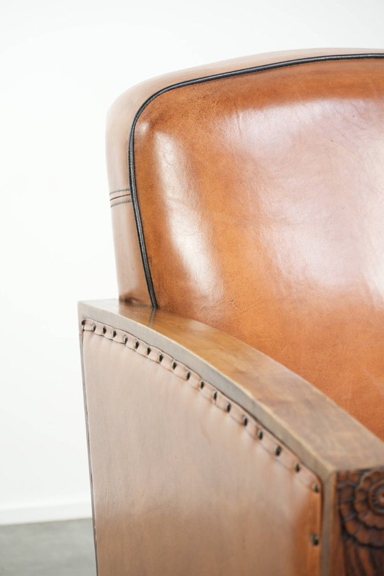 Image 1 of Schapenleren art Deco fauteuil met mooi houtsnijwerk en zwarte biezen