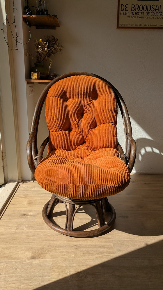 Image 1 of Draaibare rotanstoel uit de jaren 70 met oranje corduroy kussen