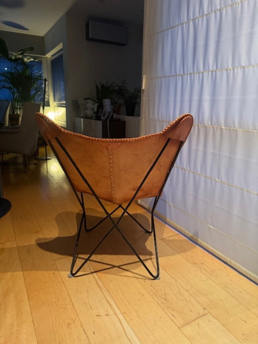Vlinderstoel in leder https://www.maisonsdumonde.com/BE/nl/p/camelkleurige-leren-vlinderstoel-santiago-121926.htm?utm_source=goo