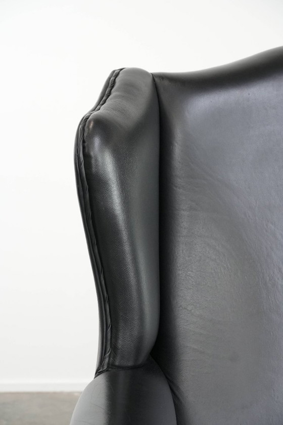 Image 1 of Smooth black cowhide Chesterfield wingback armchair in English style with color-matched piping