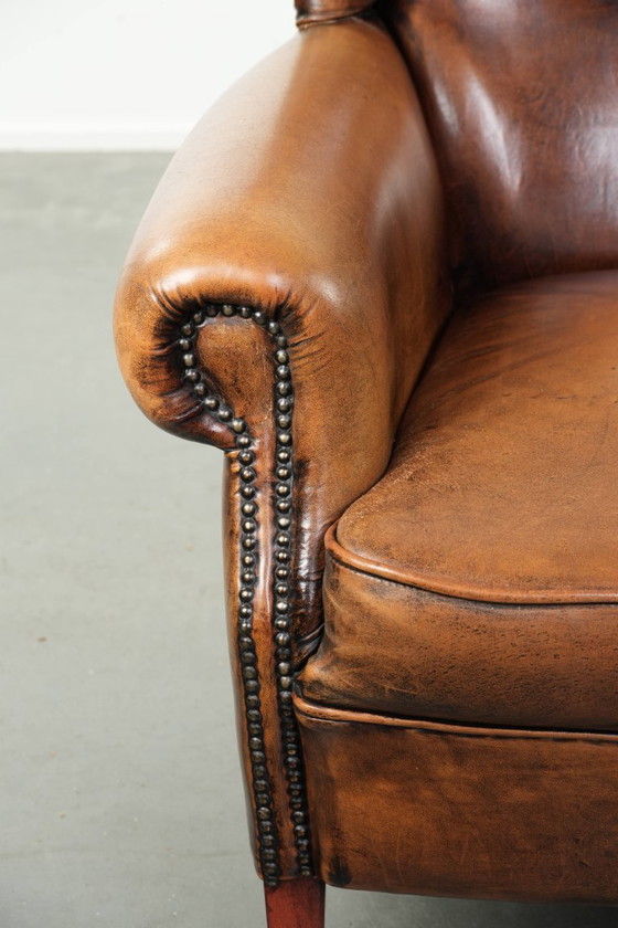 Image 1 of Comfortabele oorfauteuil gemaakt van schapenleer afgewerkt met siernagels en een karaktervolle uitstraling in Engelse stijl