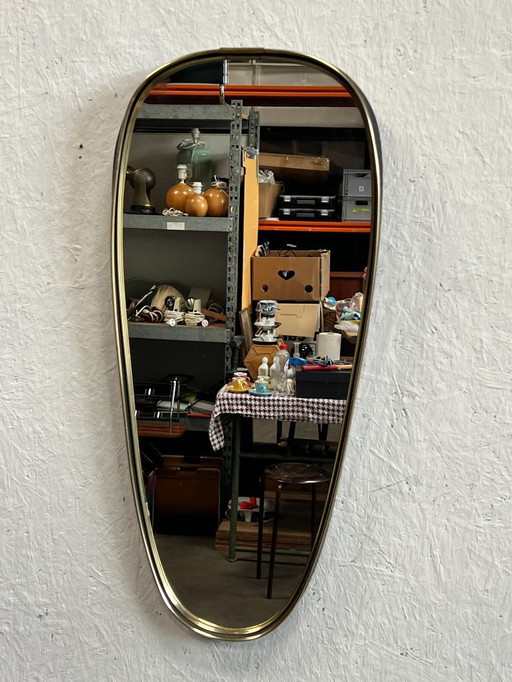 Een leuke vintage spiegel in ovale/druppelvorm. Gemaakt in Scandinavië (mogelijk Deens) in de 1960's. Voorzien van een kunststof