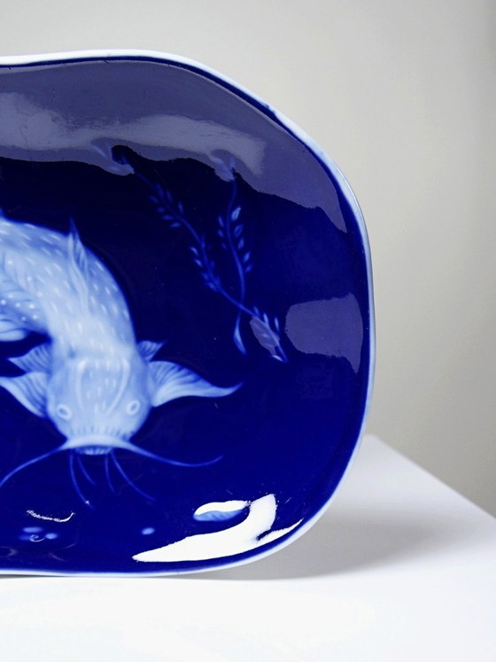 Image 1 of Plato pequeño de porcelana de Limoges con esmalte azul y decoración de peces al estilo japonés.