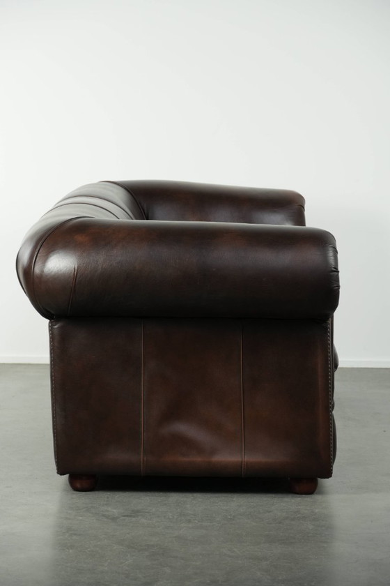 Image 1 of Conjunto de lujo de piel de vacuno marrón compuesto por un sofá Chesterfield liso y un sillón.