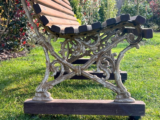 Banco de jardín clásico de madera de 180 cm con patas de hierro fundido.
