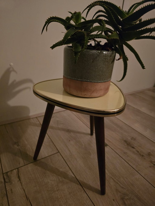 Mesa auxiliar cálida de color amarillo ocre con borde de latón y hermosa tapa de fórmica retro.