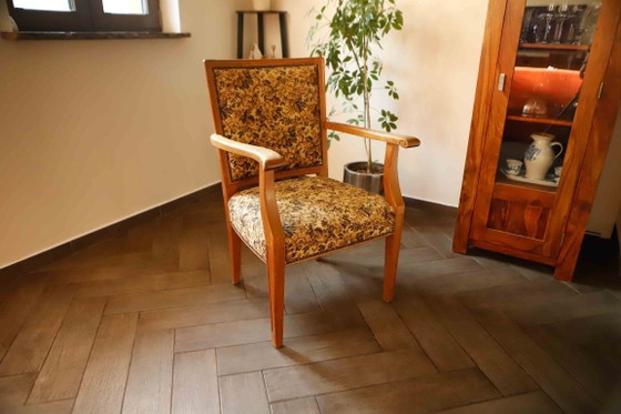 Image 1 of Vintage salonfauteuil met bloemenpatroon op de bekleding en sierlijke armleuningen.