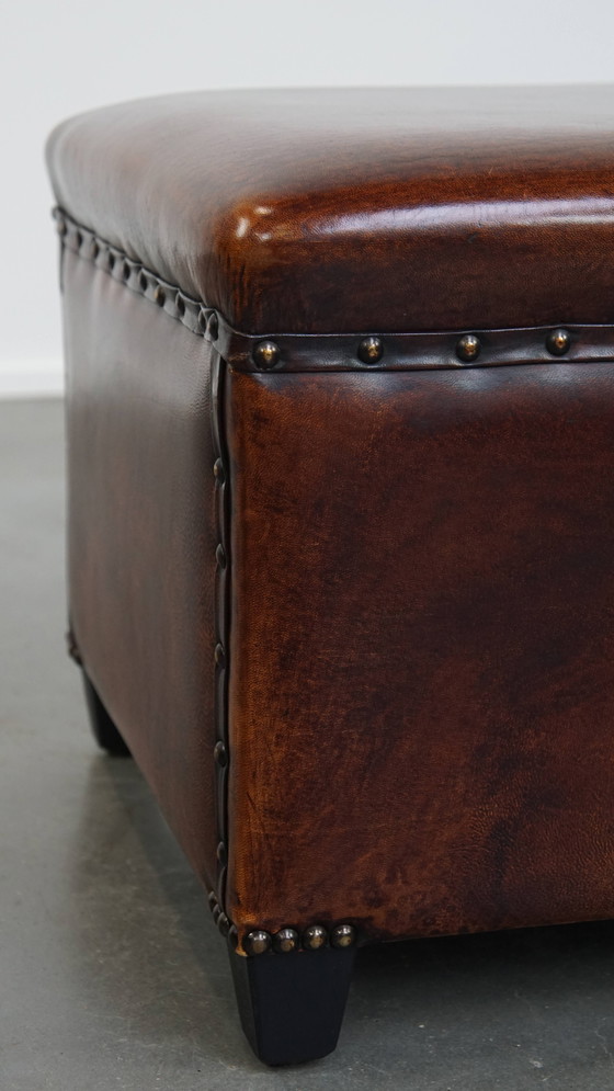 Image 1 of Cognac-kleurige schapenleren hocker met siernagels