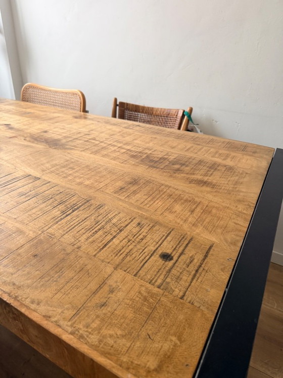 Image 1 of Mesa de comedor industrial de madera de mango con base de metal.