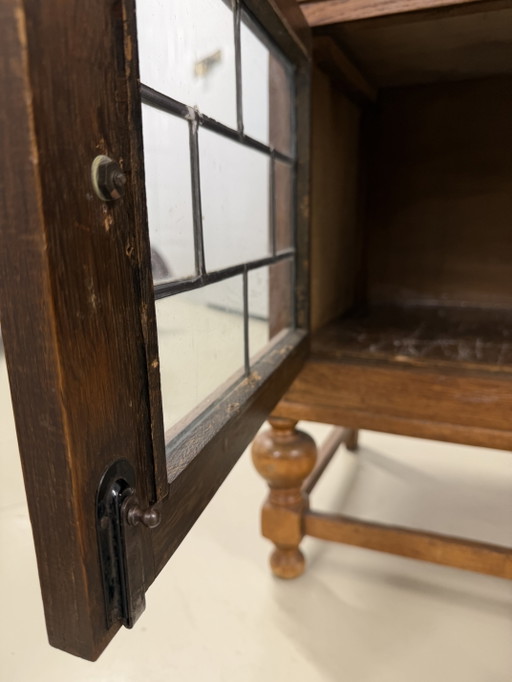 houten kast met twee deuren van loodglas en lade