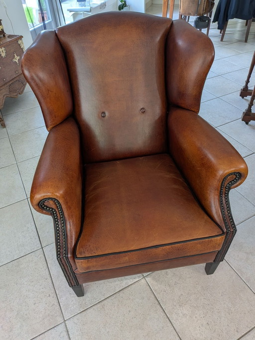 A sheepskin leather wingback armchair in very good condition
