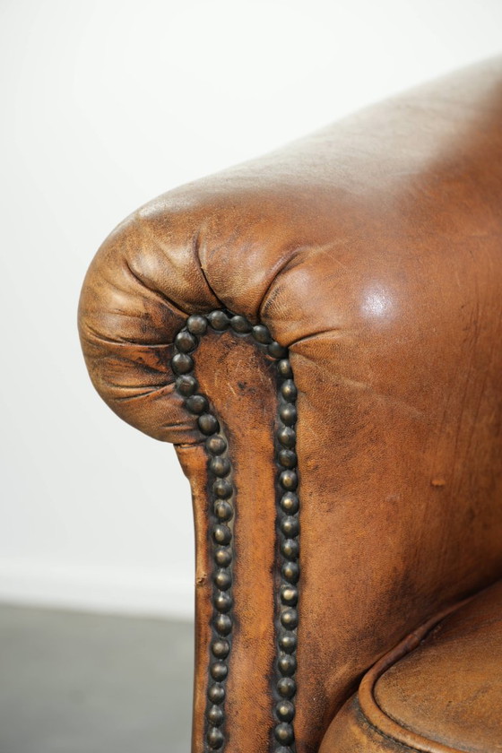 Comoda poltrona in pelle di pecora, dal carattere deciso, rifinita con borchie decorative e una splendida (photo 10 of 13)