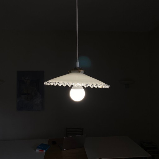Lámpara colgante antigua con pantalla de cristal opalino blanco y borde ondulado transparente.